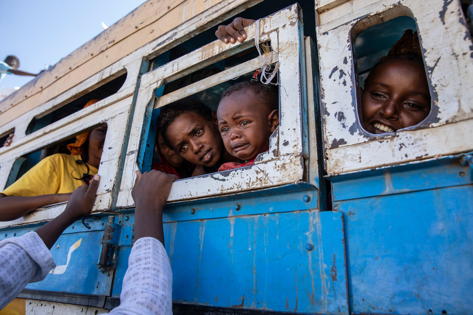  Tigray refugees who fled the conflict in the Ethiopia's Tigray ride a bus going to the Village 8 temporary shelter, near the Sudan-Ethiopia border, in Hamdayet, eastern Sudan, Tuesday, Dec. 1, 2020. (AP Photo/Nariman El-Mofty) 