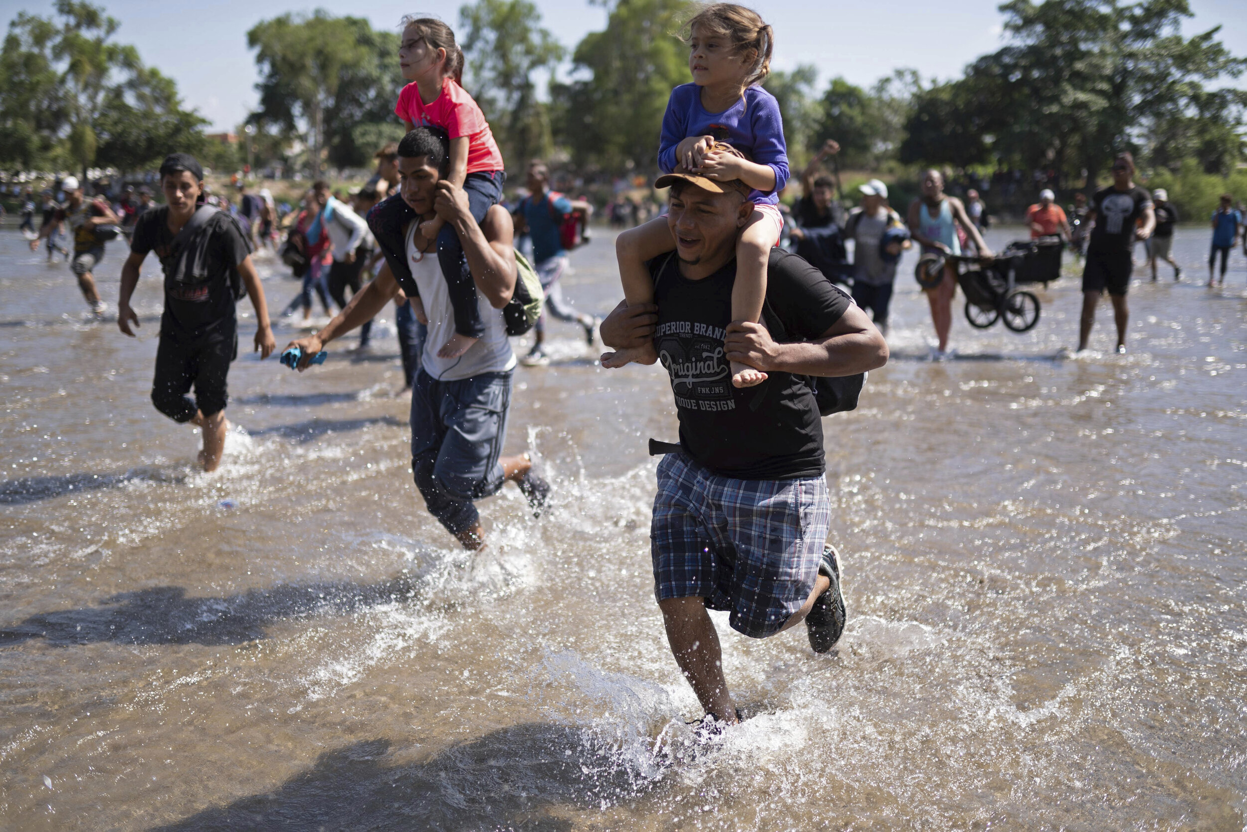  Central American migrants carry children across the Suchiate River from Guatemala to Mexico, near Ciudad Hidalgo, Mexico, Monday, Jan. 20, 2020, in hopes of convincing Mexican authorities to allow them passage through the country so they could reach