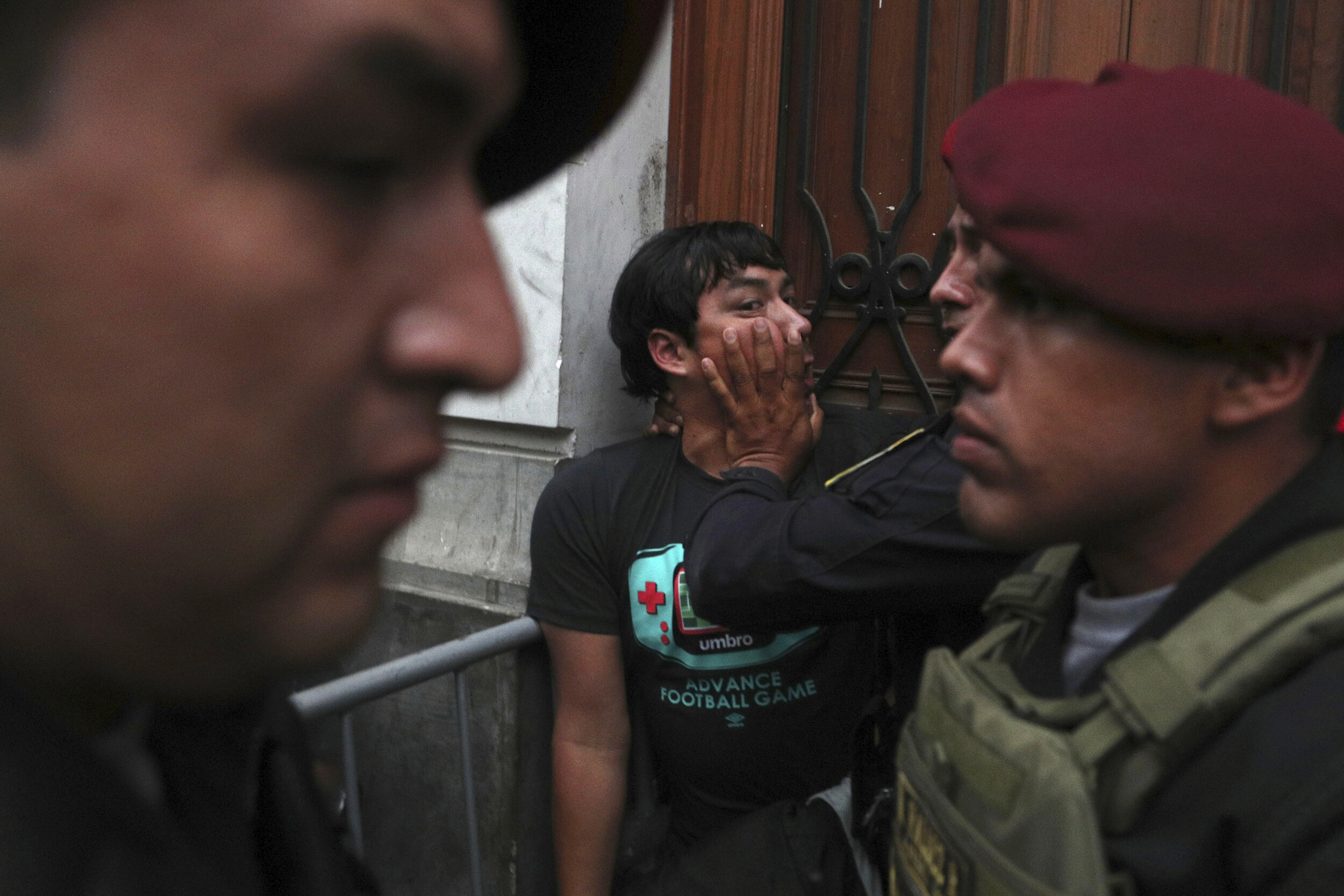  A supporter of Keiko Fujimori, the daughter of Peru's former President Alberto Fujimori and opposition leader, is held back by police officers outside a courtroom in Lima, Peru, Tuesday, Jan. 28, 2020. A Peruvian judge ordered 15 months of preventiv