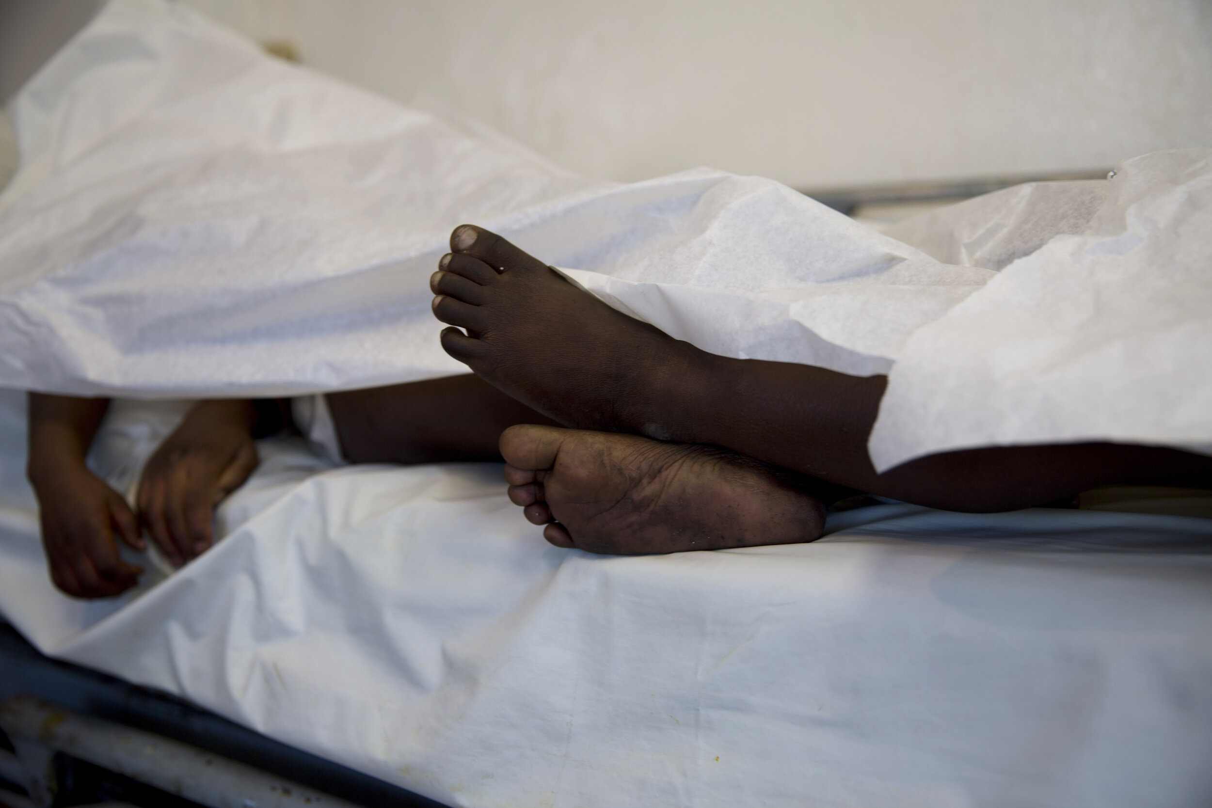  The feet and hands of children who died in a fire at the Orphanage of the Church of Bible Understanding extend beyond the sheet they lie under on a bed at Baptiste Mission Hospital in Kenscoff, on the outskirts of Port-au-Prince, Haiti, Friday, Feb.