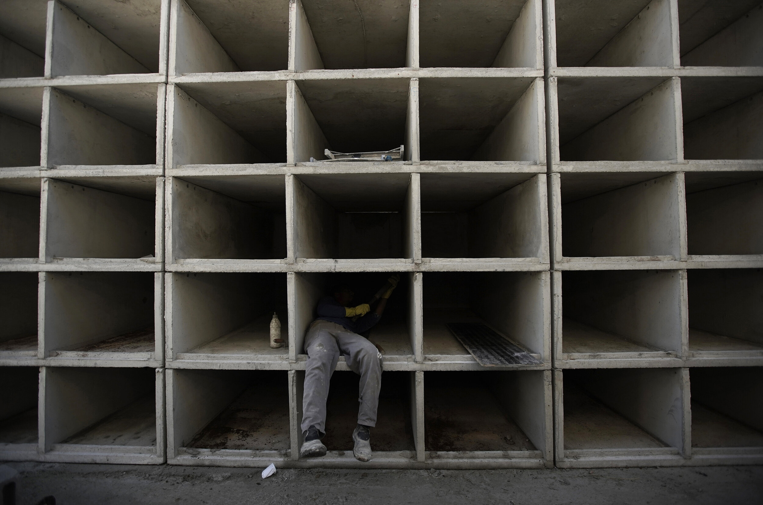  A worker builds niches at the Caju Cemetery in Rio de Janeiro, Brazil, Monday, April 20, 2020. There were already plans this year to create more tombs at Caju but the new coronavirus pandemic accelerated the construction. (AP Photo/Silvia Izquierdo)