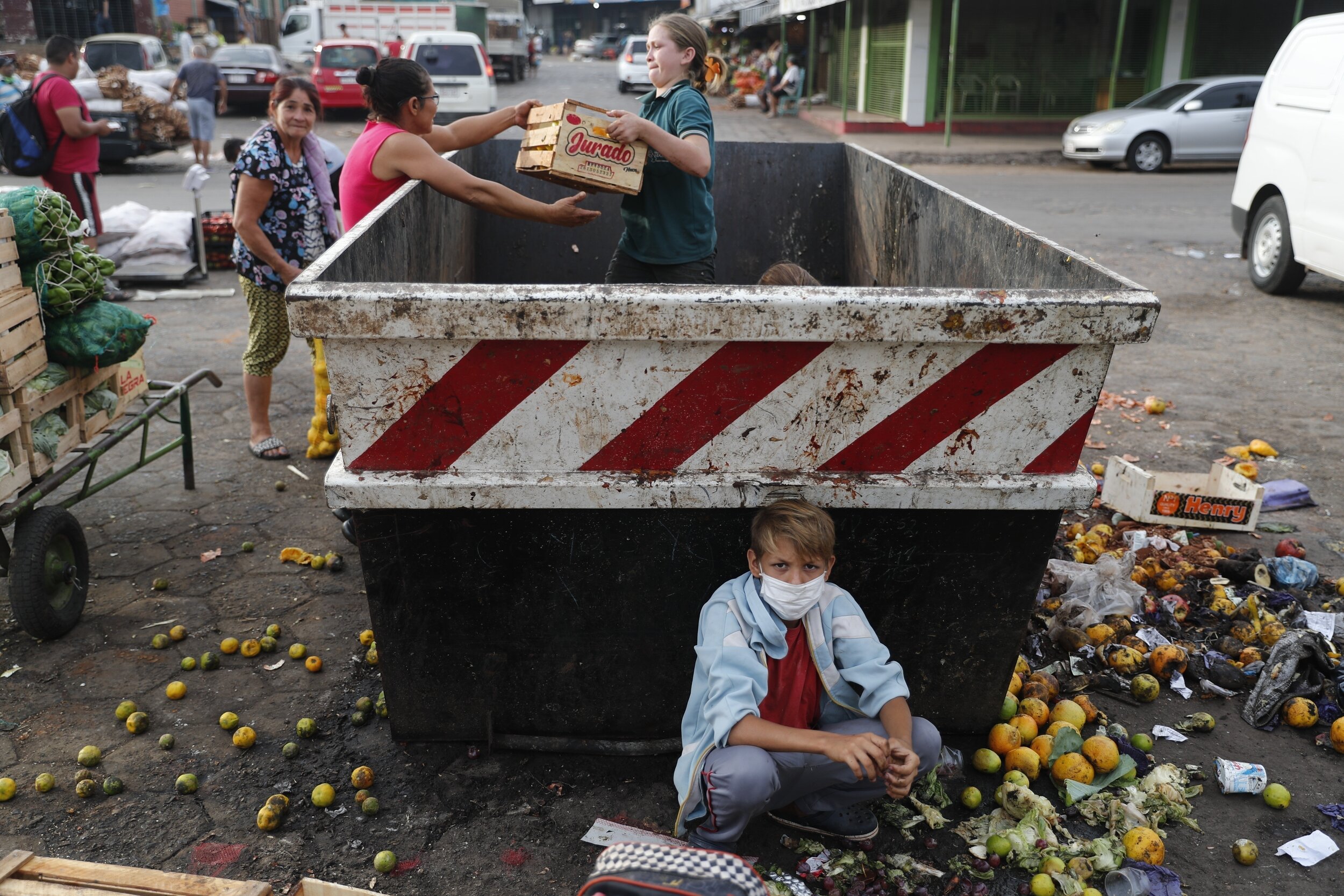  Fabian Ramirez, 11, and members of his family scavenge a trash container for discarded vegetables at the "Mercado de Abasto," a market for vendors, during the fourth week of quarantine to contain the spread of the new coronavirus in Asuncion, Paragu