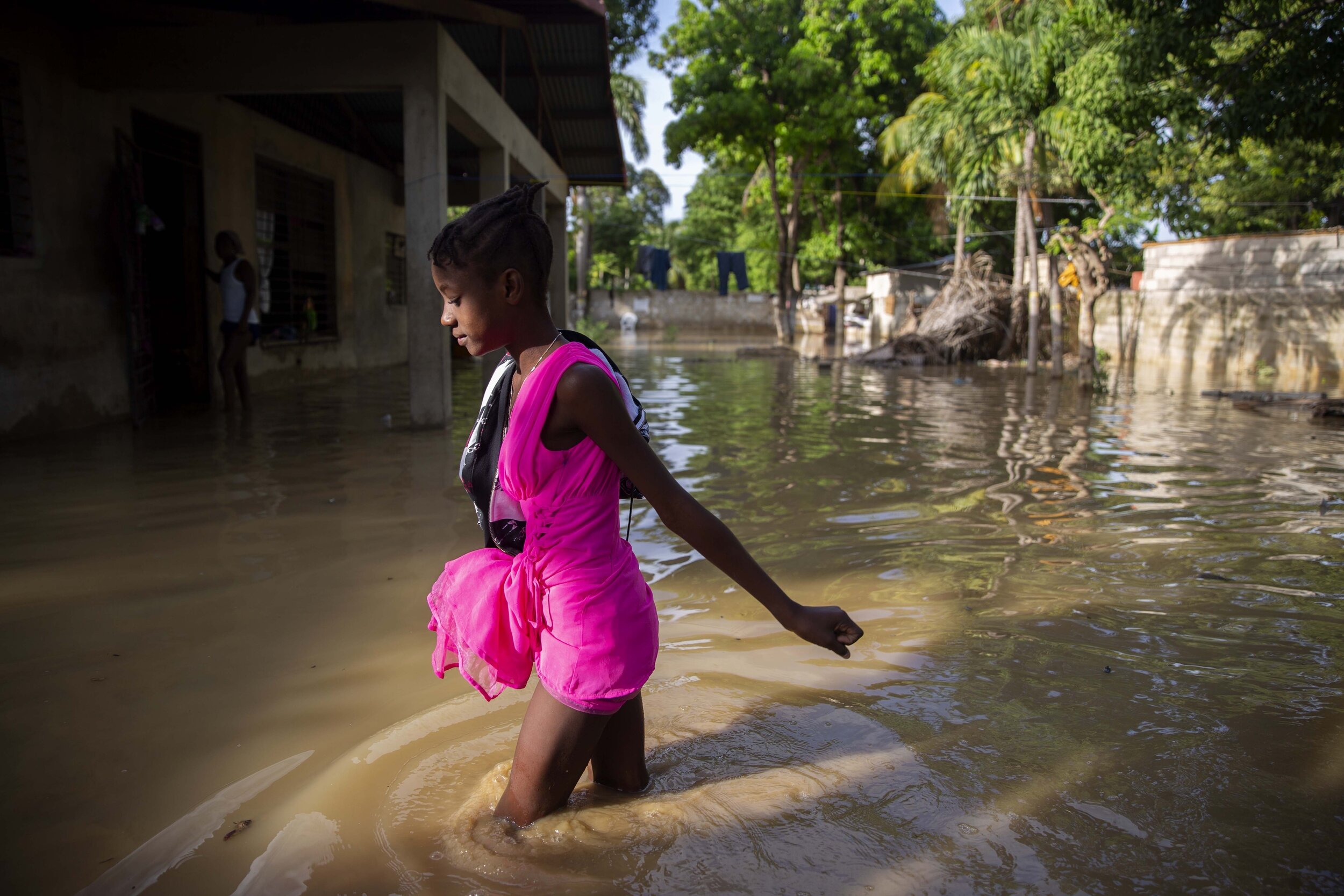  A girl wades to her flooded home one day after the passing of Tropical Storm Laura in Port-au-Prince, Haiti, Monday, Aug. 24, 2020. (AP Photo/Dieu Nalio Chery) 