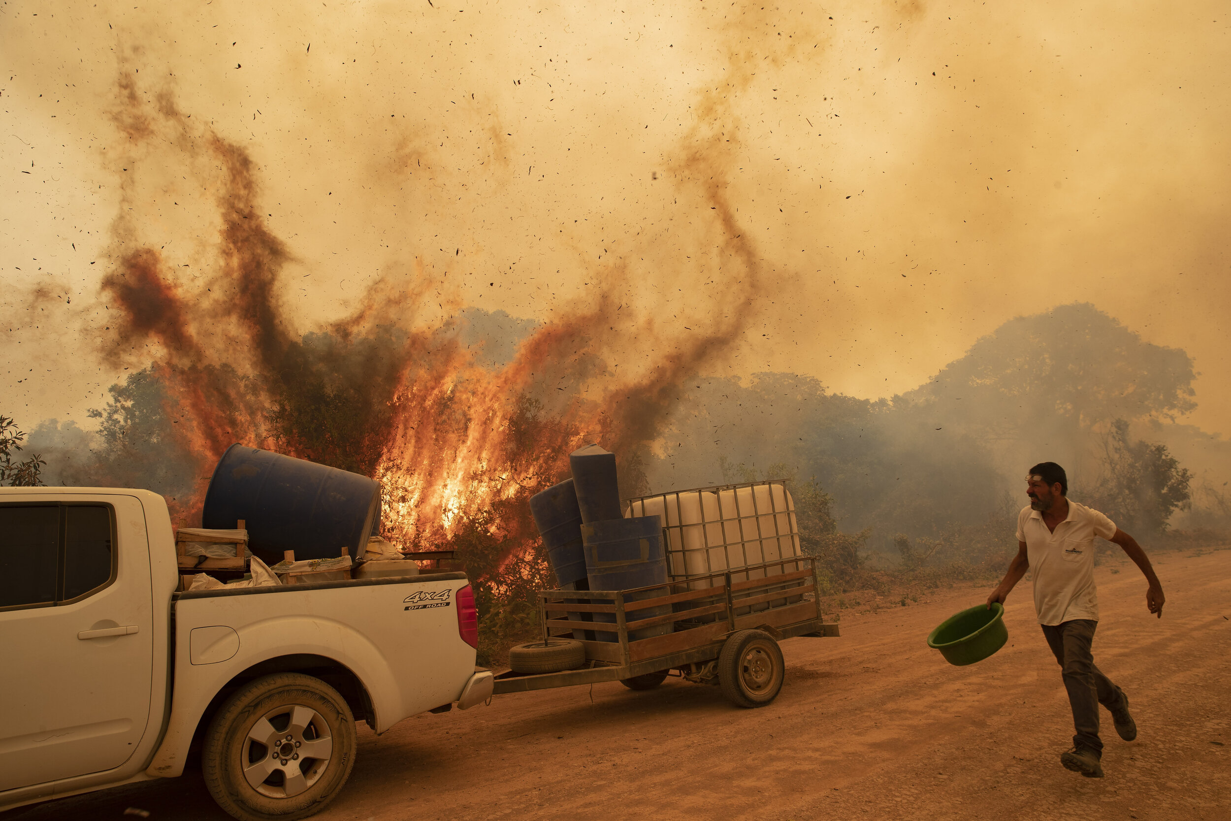  Volunteer Divino Humberto tries to douse the fire with a bucket along a dirt road off the Trans-Pantanal highway in the Pantanal wetlands near Pocone, Mato Grosso state, Brazil, Friday, Sept. 11, 2020. (AP Photo/Andre Penner) 