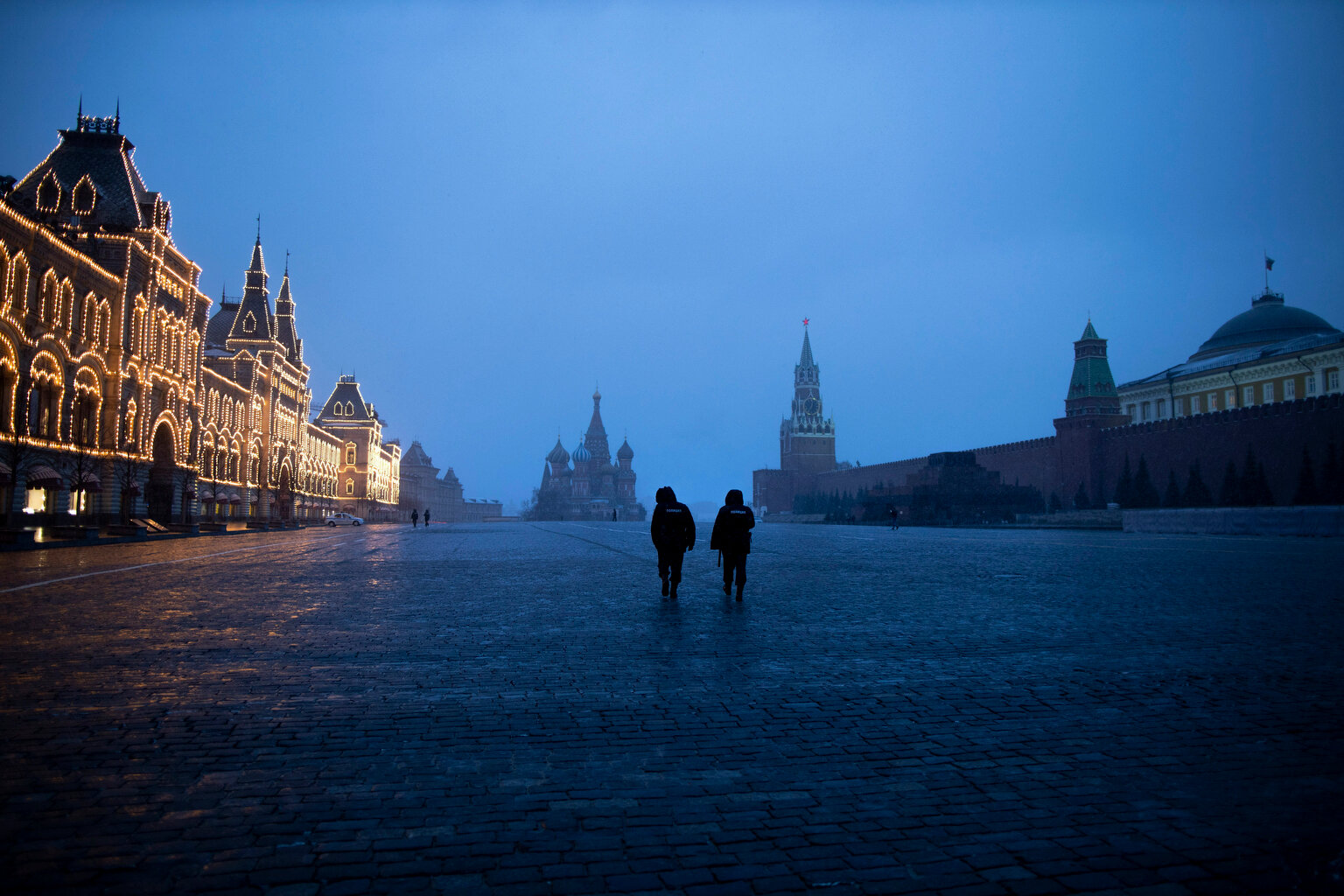  Two police officers patrol an almost empty Red Square, with St. Basil's Cathedral, center, and Spasskaya Tower and the Kremlin Wall, right, at the time when its usually very crowded in Moscow, Russia, Monday, March 30, 2020. (AP Photo/Alexander Zeml