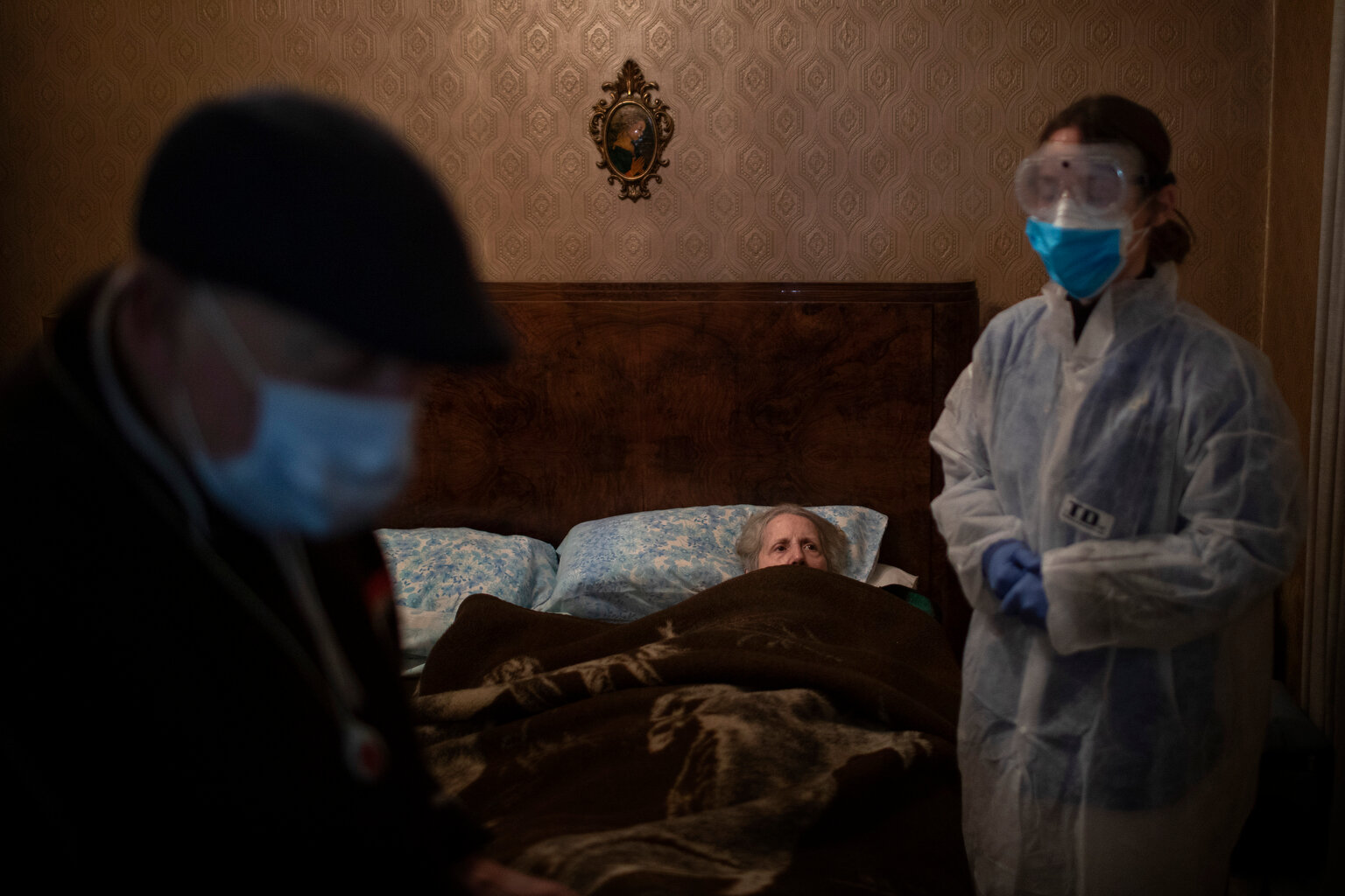  Josefa Ribas, 86, who is bedridden, looks at nurse Alba Rodriguez as Ribas’ husband, Jose Marcos, 89, stands by in their home in Barcelona, Spain, March 30, 2020, during the coronavirus outbreak. Ribas suffers from dementia, and Marcos fears for the