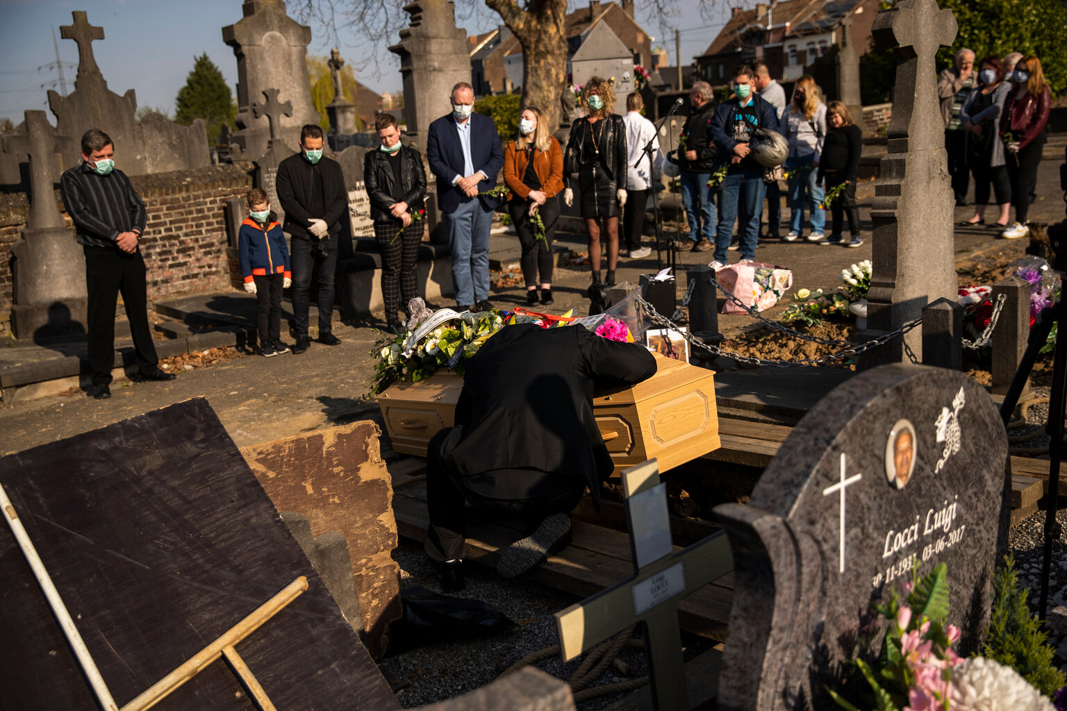  A relative of Margodt Genevieve, who died due to Covid-19, grieves over her coffin during her funeral ceremony at the Montignies cemetery in Charleroi, Belgium, Wednesday, April 8, 2020.  (AP Photo/Francisco Seco) 