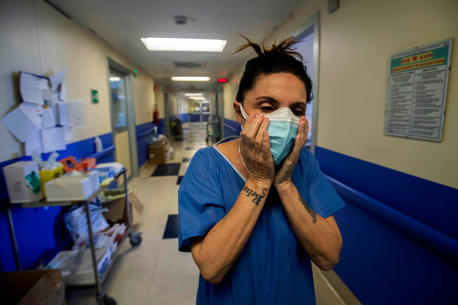  In this photo taken on Friday, April 10, 2020 nurse Cristina Settembrese fixes two masks to her face during her work shift in the COVID-19 ward at the San Paolo hospital in Milan, Italy. Settembrese spends her days caring for COVID-19 patients in a 