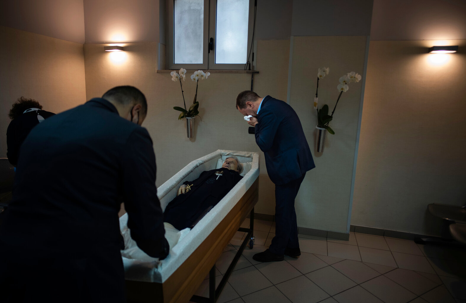 Sabatino Di Girolamo, right, mayor of Roseto degli Abruzzi mourns his mother Annunziata, laid in state in the morgue of the Giuseppe Mazzini Hospital in Teramo, central Italy, Tuesday, May 12, 2020. (AP Photo/Domenico Stinellis) 