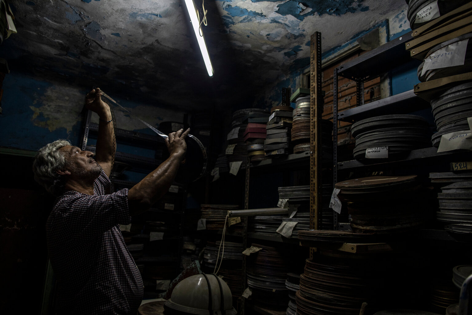  Projector operator Pavlos Lepeniotis checks the quality of a movie film inside a warehouse at the Zephyros open-air cinema that specializes in films from past decades in Ano Petralona, central Athens, June 3, 2020. Lepeniotis has worked in movie the