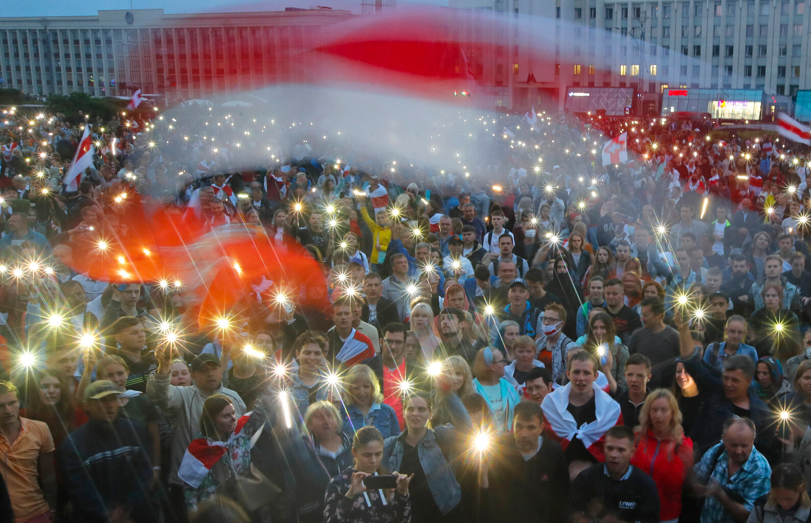  Belarusian opposition supporters activate the lights on their phones and wave old Belarusian national flags during a protest rally in front of the government building at Independent Square in Minsk, Belarus, Wednesday, Aug. 19, 2020. (AP Photo/Dmitr