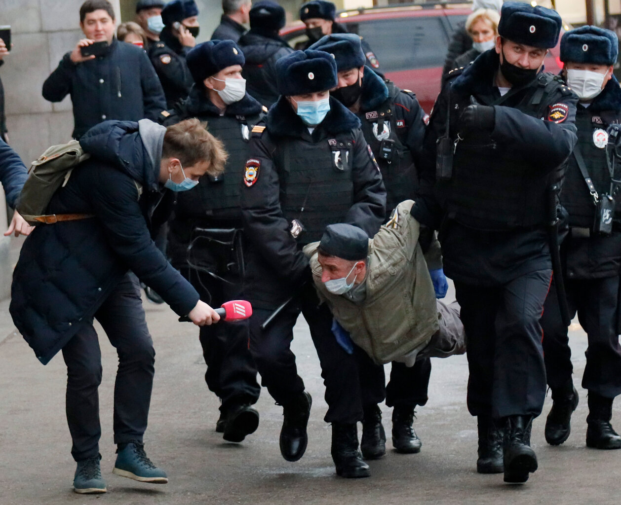  A Russian TVRain channel journalist tries to give an interview as police officers wearing face masks to help curb the spread of the coronavirus detain a Russian nationalist, during an unsanctioned action to mark National Unity Day in Moscow, Russia,