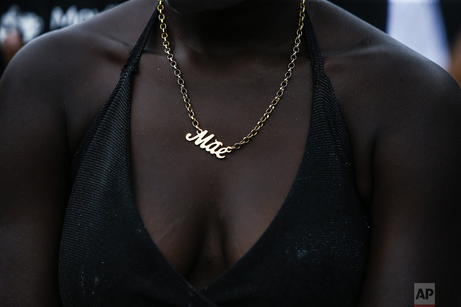 A woman wearing a necklace with the word "Mother" in Portuguese protests the killing of 4-year-old Emily Victoria Silva dos Santos, and 7-year-old Rebeca Beatriz Rodrigues dos Santos, in Duque de Caxias, Rio de Janeiro state, Brazil, Sunday, Dec. 6, 2020. The cousins were killed by stray bullets while playing outside their homes. (AP Photo/Bruna Prado)