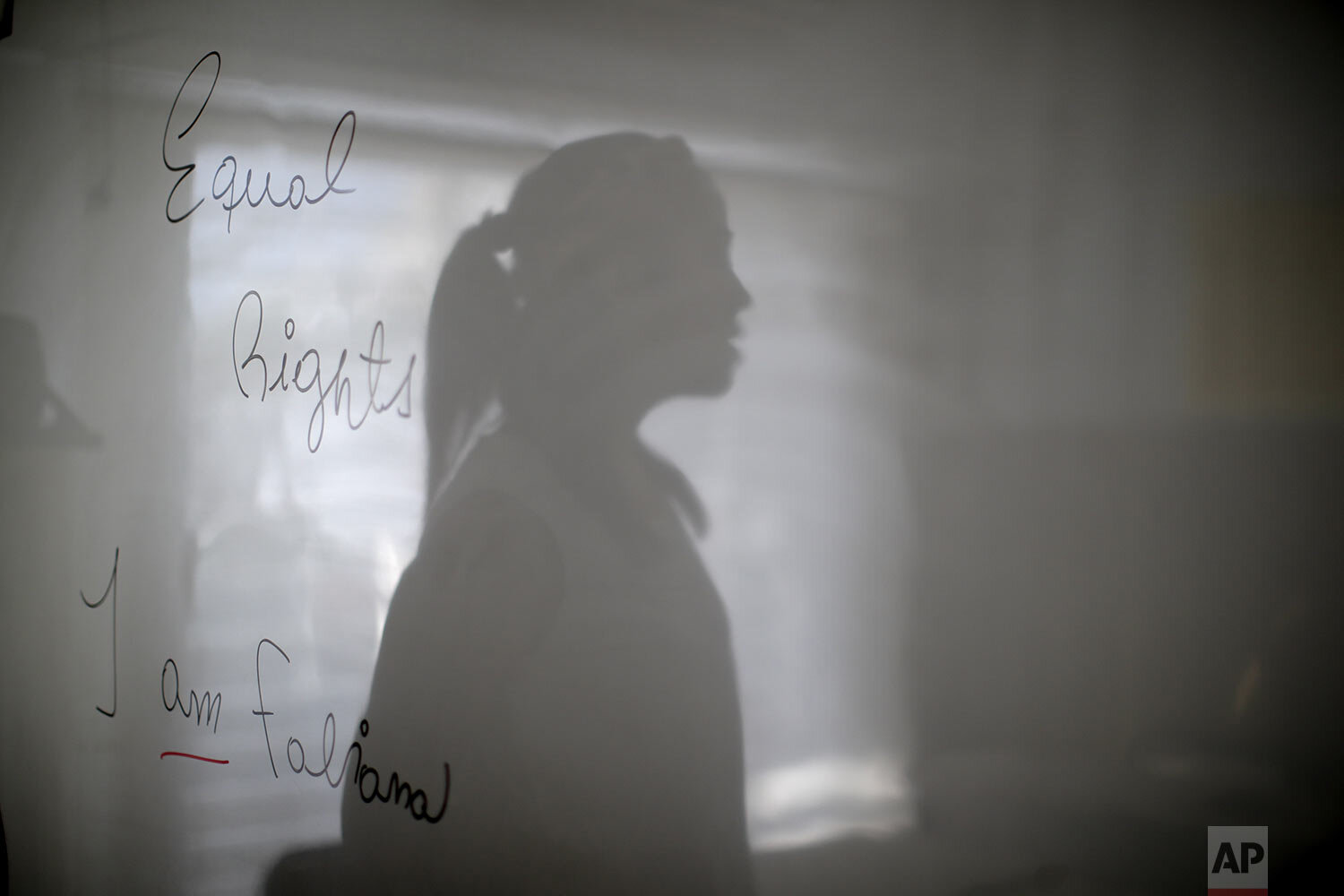  Transgender woman Fabiana Rodríguez, an English teacher, poses for a portrait with her shadow overlaying the message she wrote on her blackboard: "Equal rights, I am Fabiana" during an interview at the English Institute where she works as a language