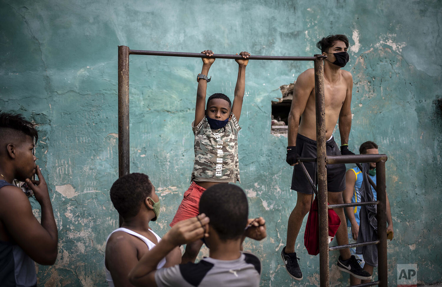 Youths exercise at a street gym in Havana, Cuba, Monday, Dec. 21, 2020, during the COVID-19 pandemic. (AP Photo/Ramon Espinosa)
