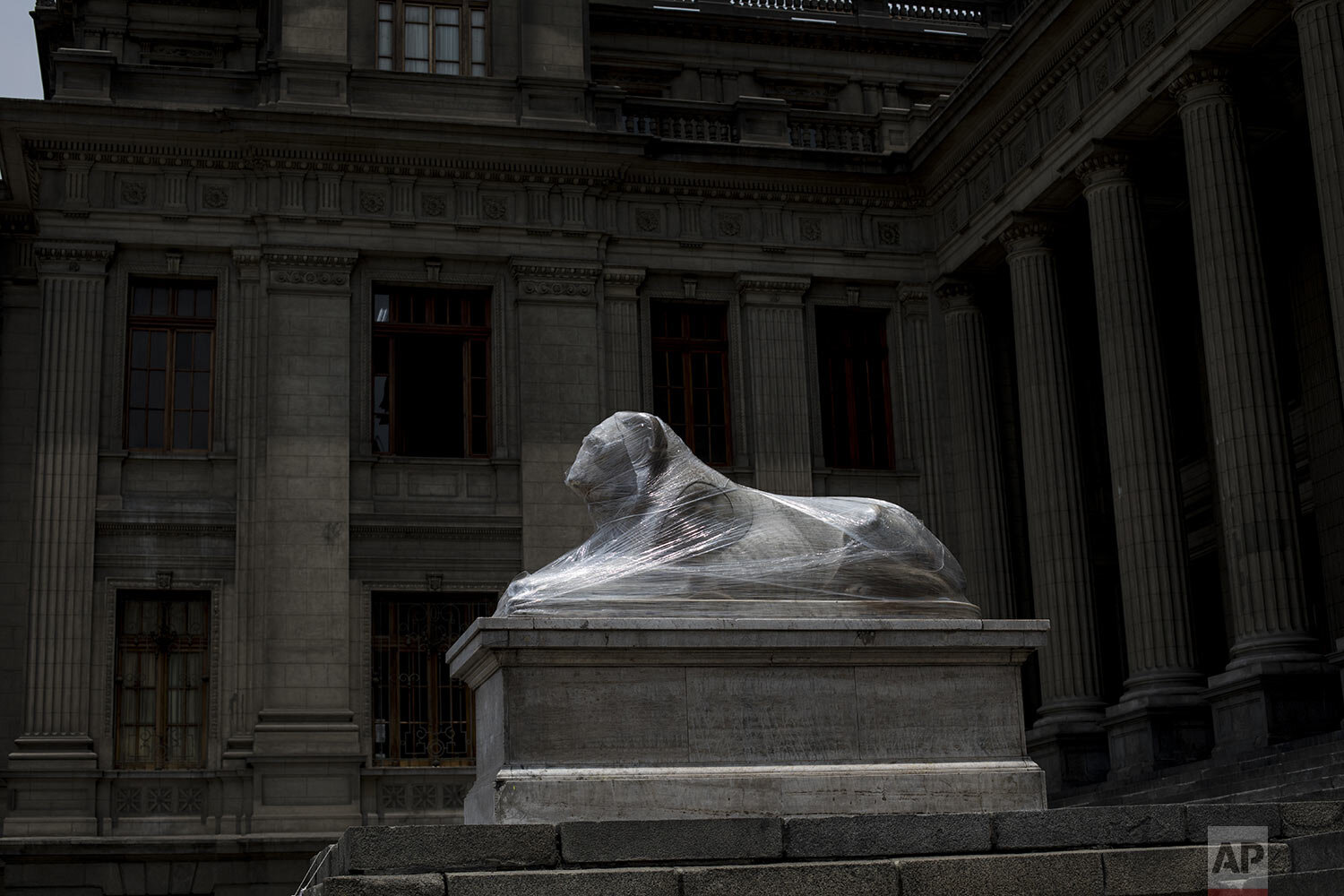  A lion statue outside the Palace of Justice is wrapped in plastic during maintenance in Lima, Peru, Tuesday, Dec. 1, 2020. Monuments were practically spared by protesters decrying a parliamentary coup in early November when Congress voted to oust ex