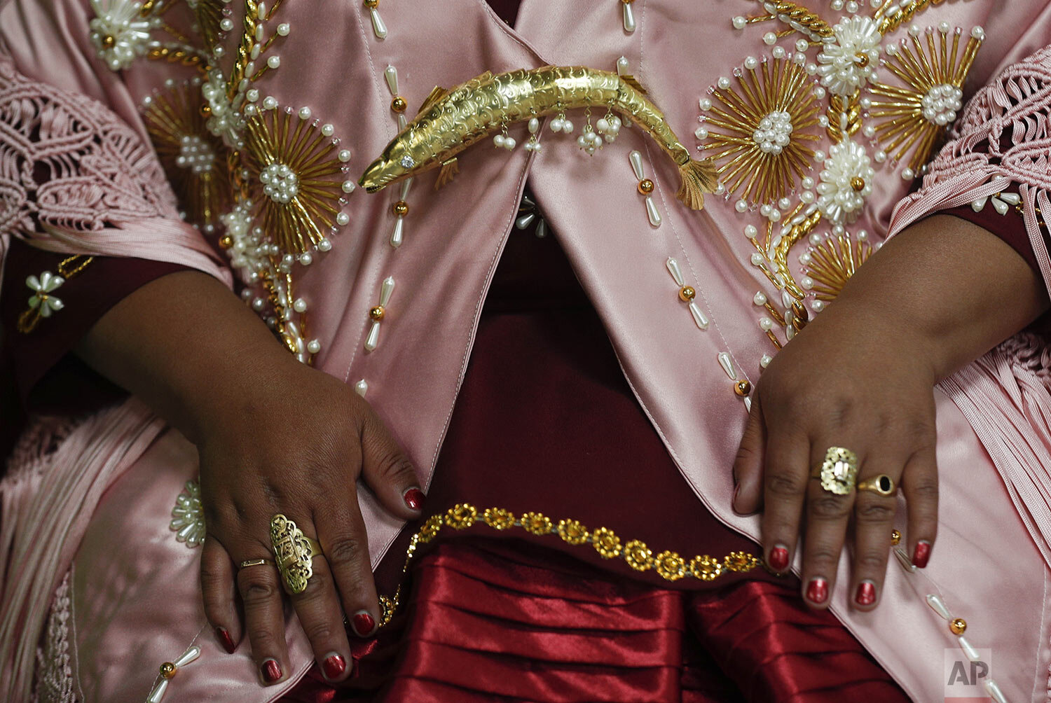 A woman shows off her jewelry before performing at a Chola fashion show in La Paz, Bolivia, Friday, Dec. 4, 2020, an event that designers and manufacturers of Chola clothing hope reactivates their economy. (AP Photo/Juan Karita)
