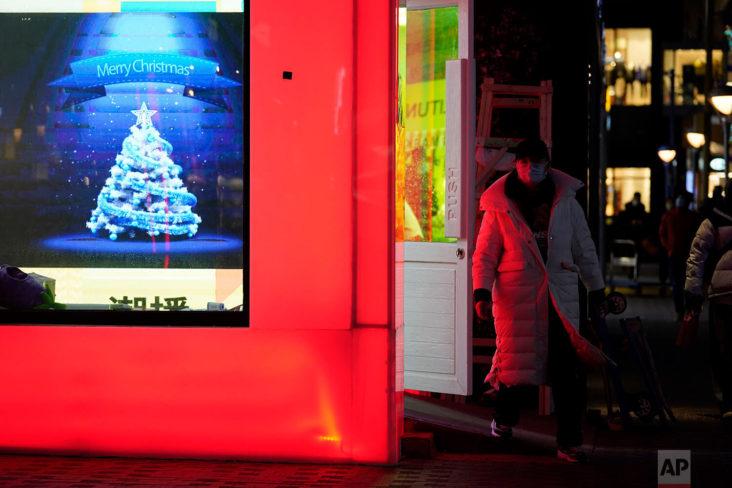  A visitor walks by Christmas decorations at a mall in Beijing, Thursday, Dec. 24, 2020. (AP Photo/Ng Han Guan) 