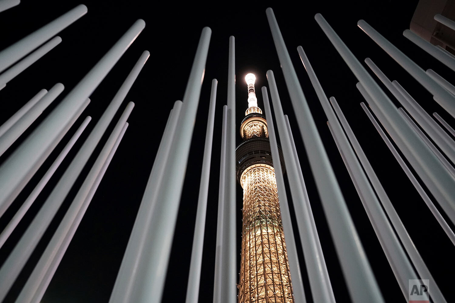  The Tokyo Skytree, the tallest tower in Japan, is illuminated with the color of the Olympic Torch, to commemorate 100 days until the torch relay begins, Tuesday, Dec. 15, 2020, in Tokyo. (AP Photo/Eugene Hoshiko) 