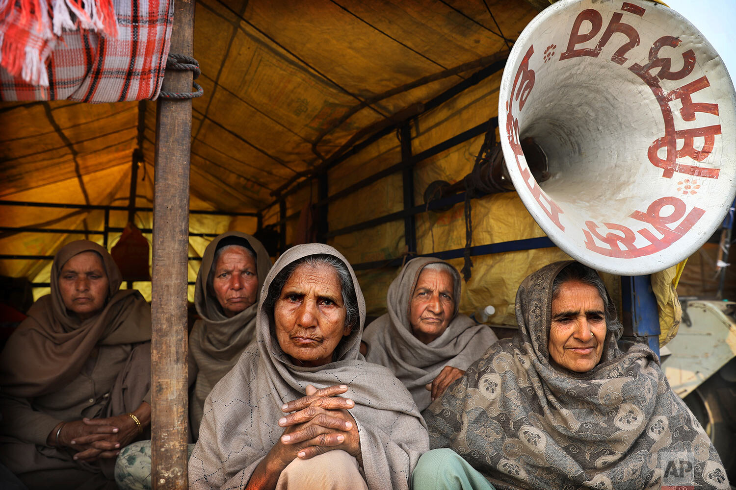  Elderly women farmers sit at the back of a trailer as they participate in a protest against new farm laws at the Delhi-Haryana state border, on the outskirts of New Delhi, India, Sunday, Dec. 27, 2020. (AP Photo/Manish Swarup) 