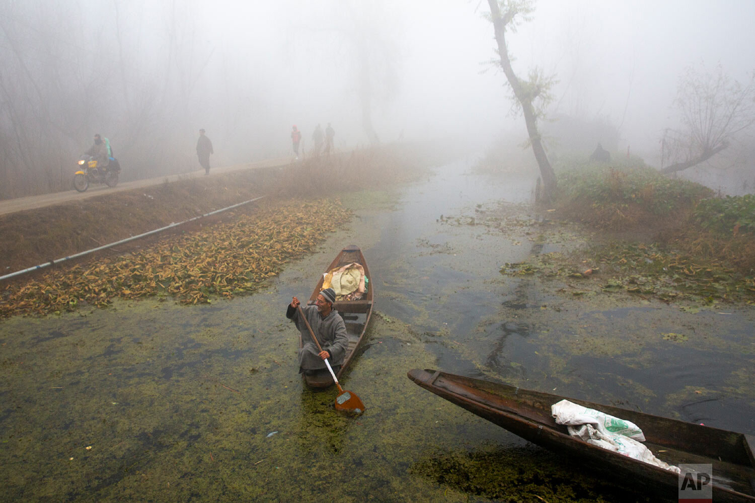  A Kashmiri boatman rows his boat in the interiors of the Dal Lake surrounded by dense fog on a cold morning in Srinagar, Indian controlled Kashmir, Indian controlled Kashmir, Thursday, Dec. 3, 2020. (AP Photo/ Dar Yasin) 