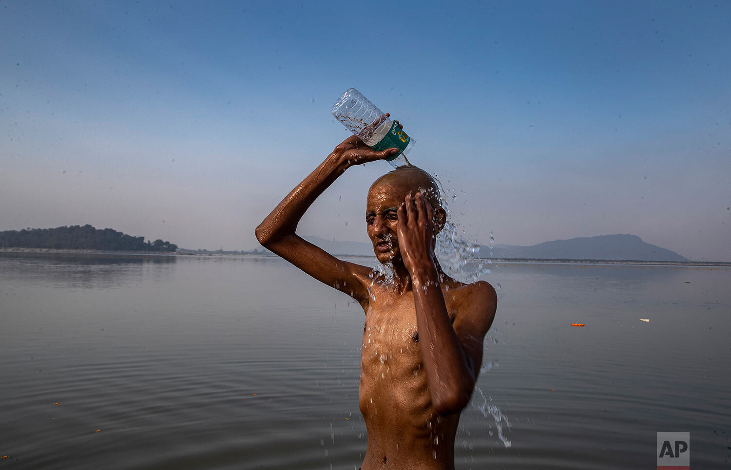  An Indian man baths after performing rituals on the banks of river Brahmaputra in Gauhati, India, Thursday, Dec. 24, 2020. (AP Photo/Anupam Nath) 