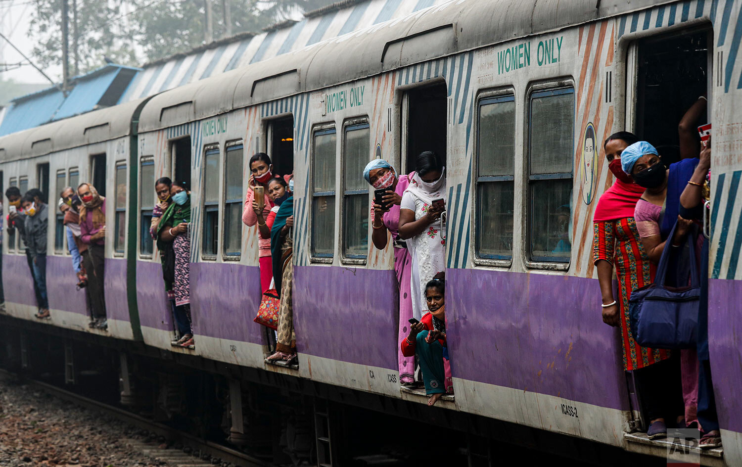  Stranded commuters of a local train look out as supporters of left parties block a train track during a nationwide shutdown called by thousands of Indian farmers protesting new agriculture laws, in Kolkata, India, Tuesday, Dec. 8, 2020.  (AP Photo/B