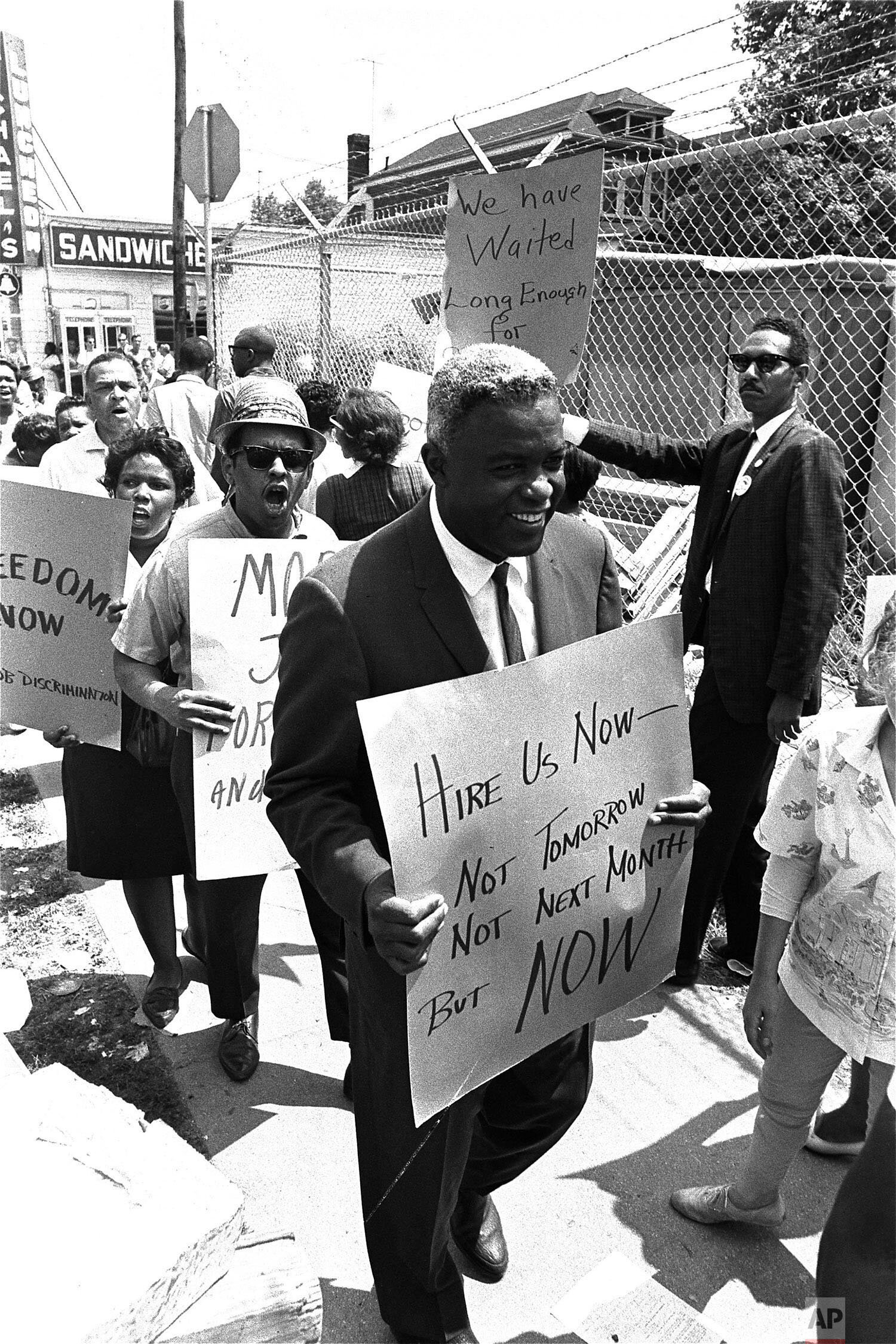  Former baseball star Jackie Robinson carries a placard as he joins pickets at the construction site of the Down State Medical Center in Brooklyn, New York City, August 2, 1963.  Robinson and members of CORE, the Congress of Racial Equality, have bee