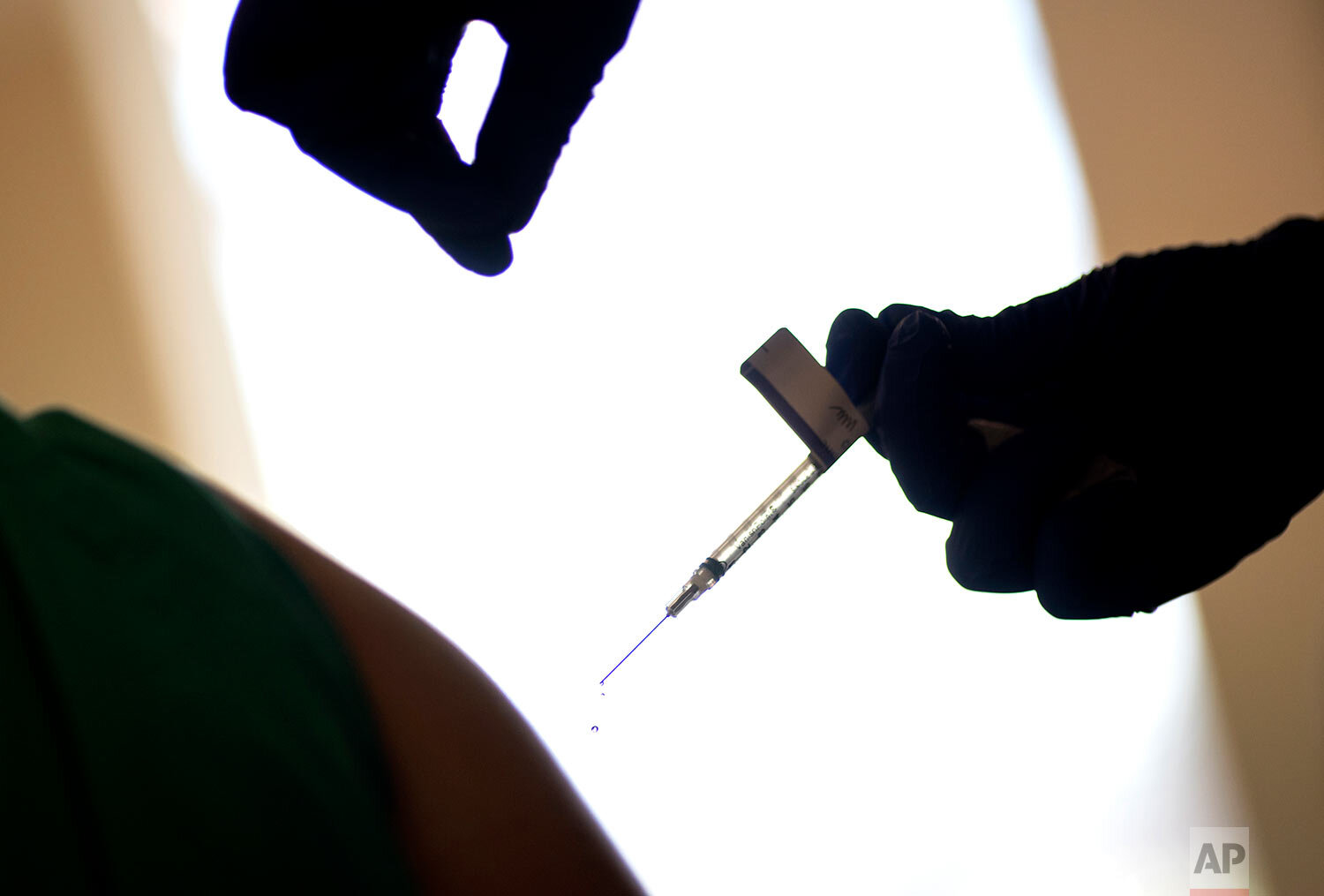  A droplet falls from a syringe after a health care worker was injected with the Pfizer-BioNTech COVID-19 vaccine at Women & Infants Hospital in Providence, R.I., Tuesday, Dec. 15, 2020. (AP Photo/David Goldman) 