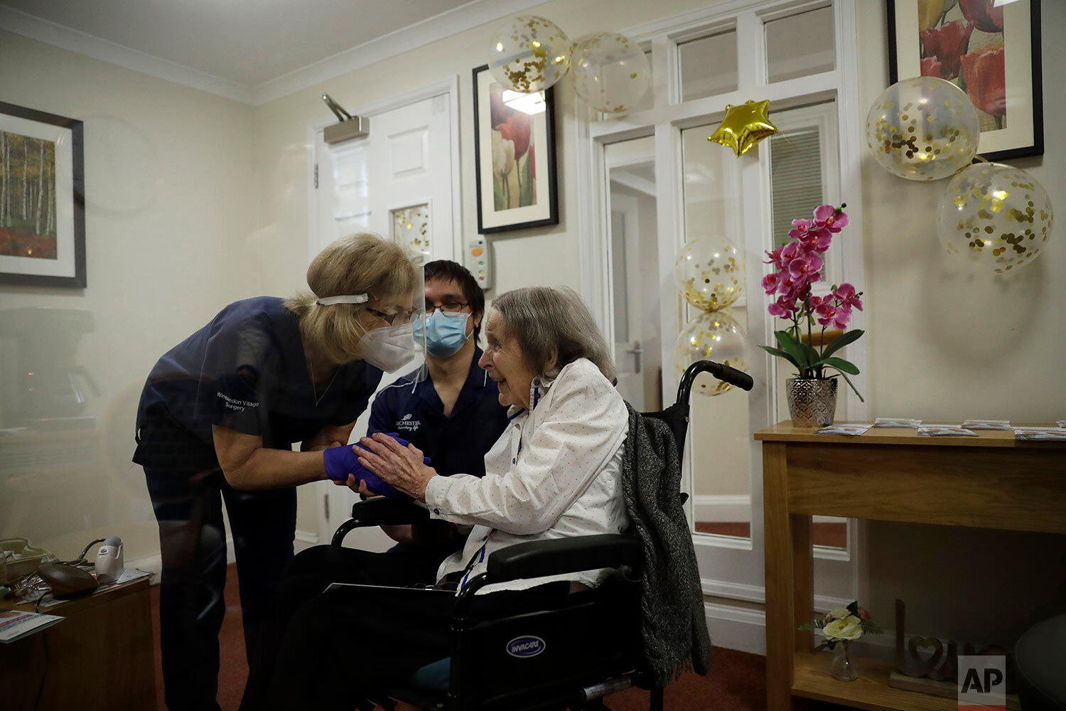  Care home resident Joan Potts, aged 102, is seen through a viewing screen installed for residents to safely receive visits from family members, as she speaks to Dr. Jane Allen after receiving her first dose of the Oxford/AstraZeneca COVID-19 vaccine