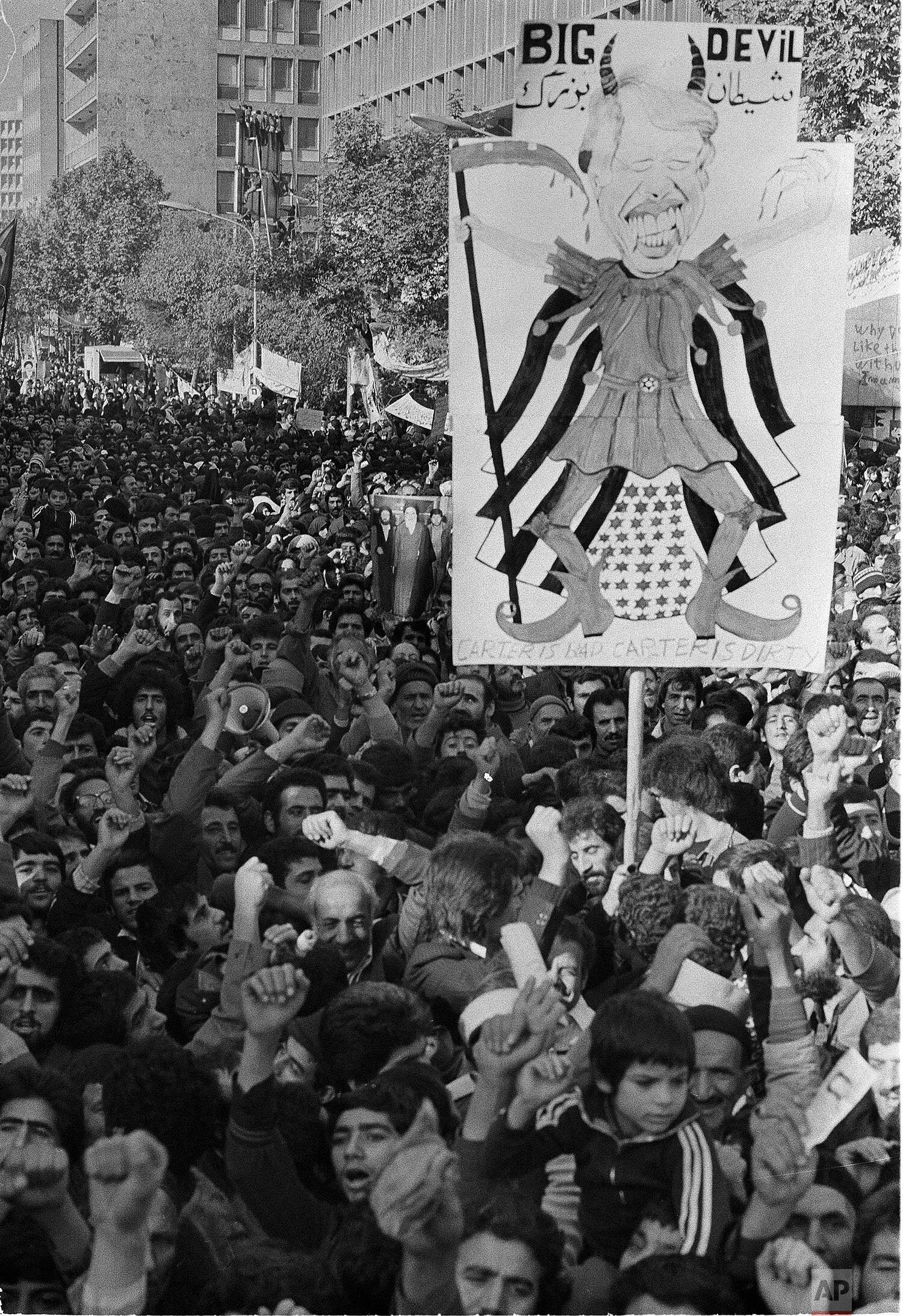  A banner depicting President Carter as a devil is carried by Iranian crowds during an anti-American march in Tehran, Nov. 21, 1979.  (AP Photo/Mohammad Sayad) 