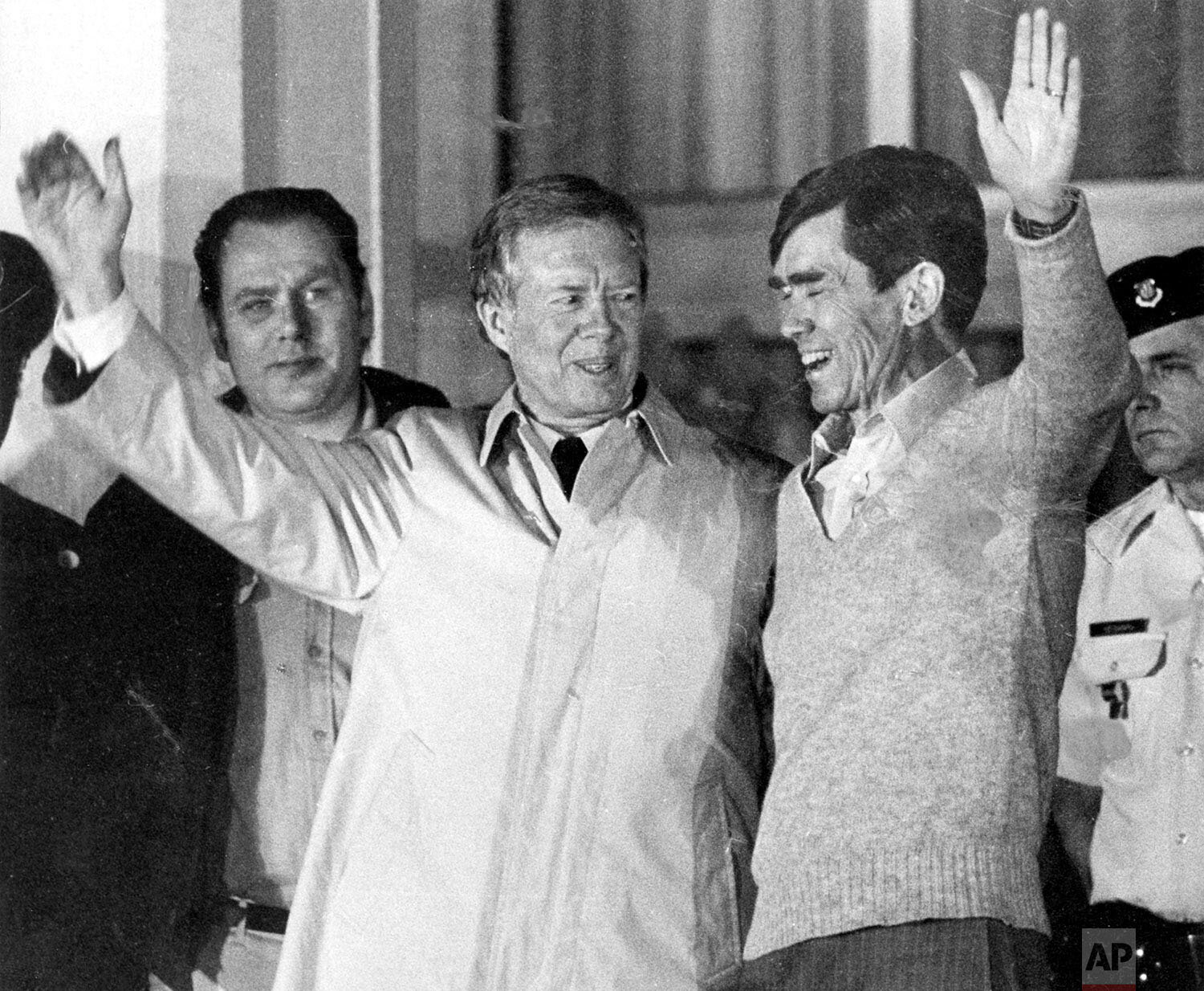  Former US President Jimmy Carter, who had negotiated for the hostages release right up to the last hours of his Presidency, lifts his arm to the crowd, while putting his other hand around the shoulders of a former hostage in Iran, believed to be Bru