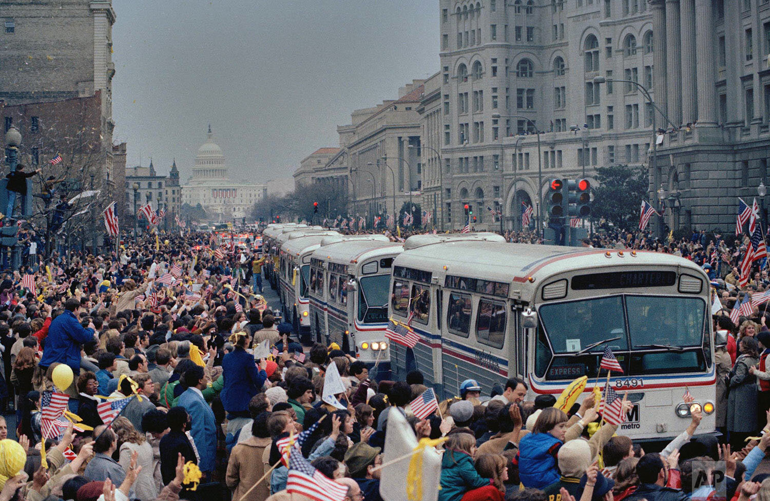  The caravan of buses carrying the former hostages and their relatives makes its way through the crowd on hand to greet them on Washington's Pennsylvania Avenue, Jan. 27, 1981.  The 52 Americans were held hostage in Iran for 444 days after their capt