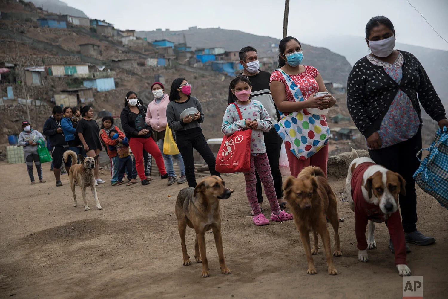 Residents stand in line to receive a free lunch from a "community pot," in the Nueva Esperanza neighborhood of Lima, Peru, Saturday, June 6, 2020. (AP Photo/Rodrigo Abd)