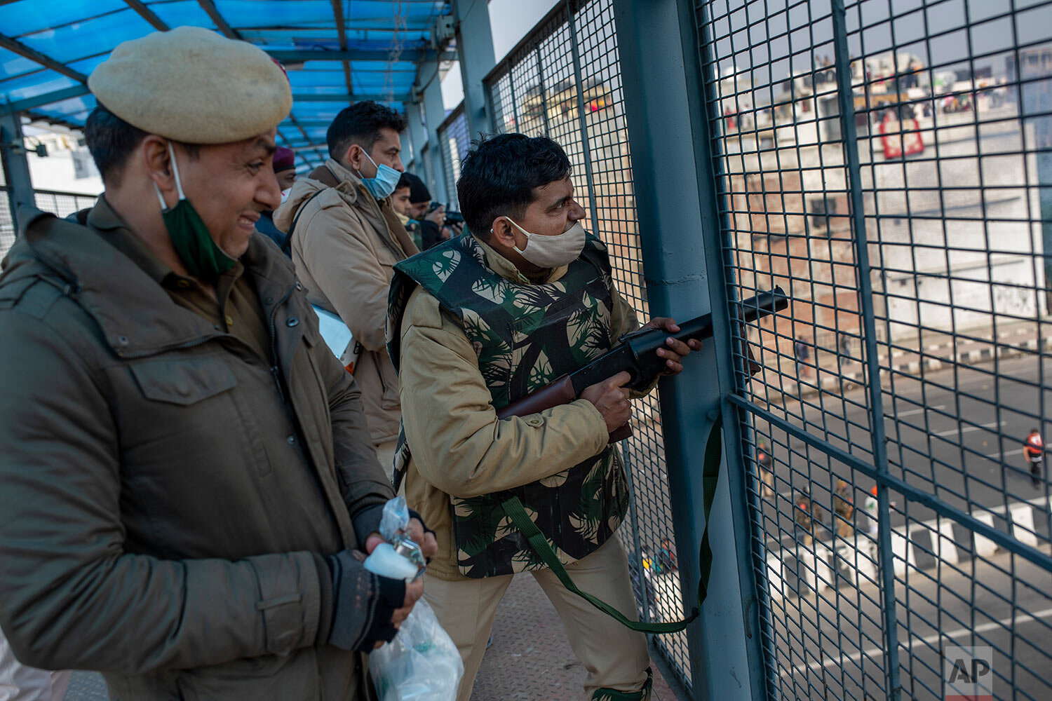  An Indian policeman fires tear gas shells towards protesting farmer as they march to the capital breaking police barricades during India's Republic Day celebrations in New Delhi, India, Tuesday, Jan. 26, 2021. (AP Photo/Altaf Qadri) 