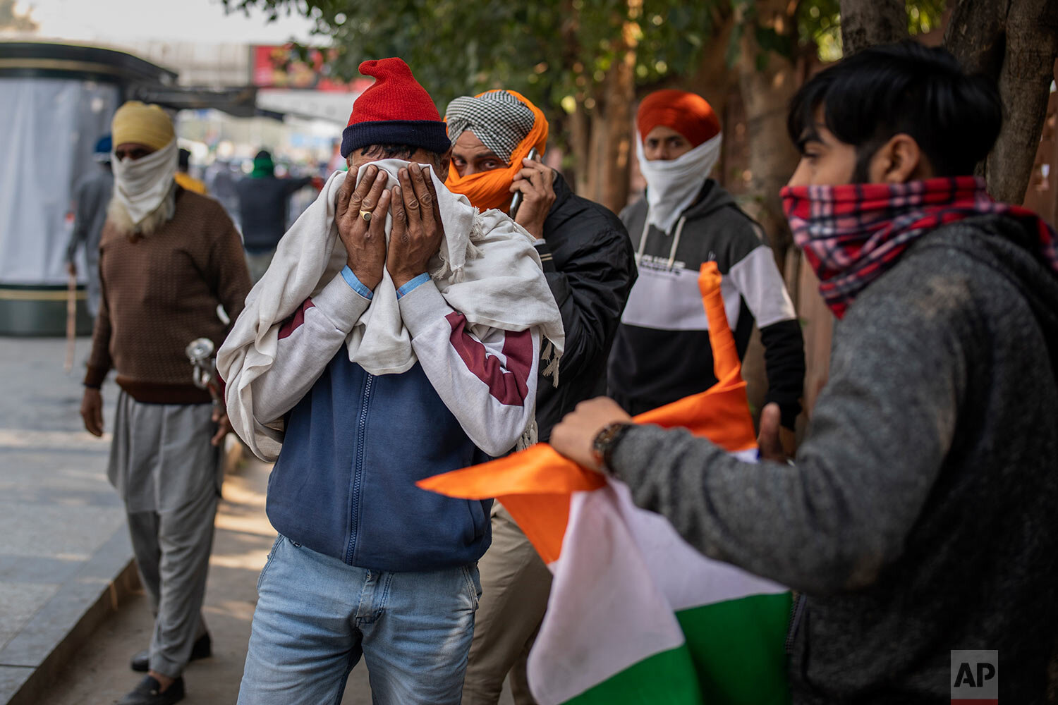  Protesting farmers cover their faces to escape tear gas smoke as they march to the capital breaking police barricades during India's Republic Day celebrations in New Delhi, India, Tuesday, Jan. 26, 2021. (AP Photo/Altaf Qadri) 