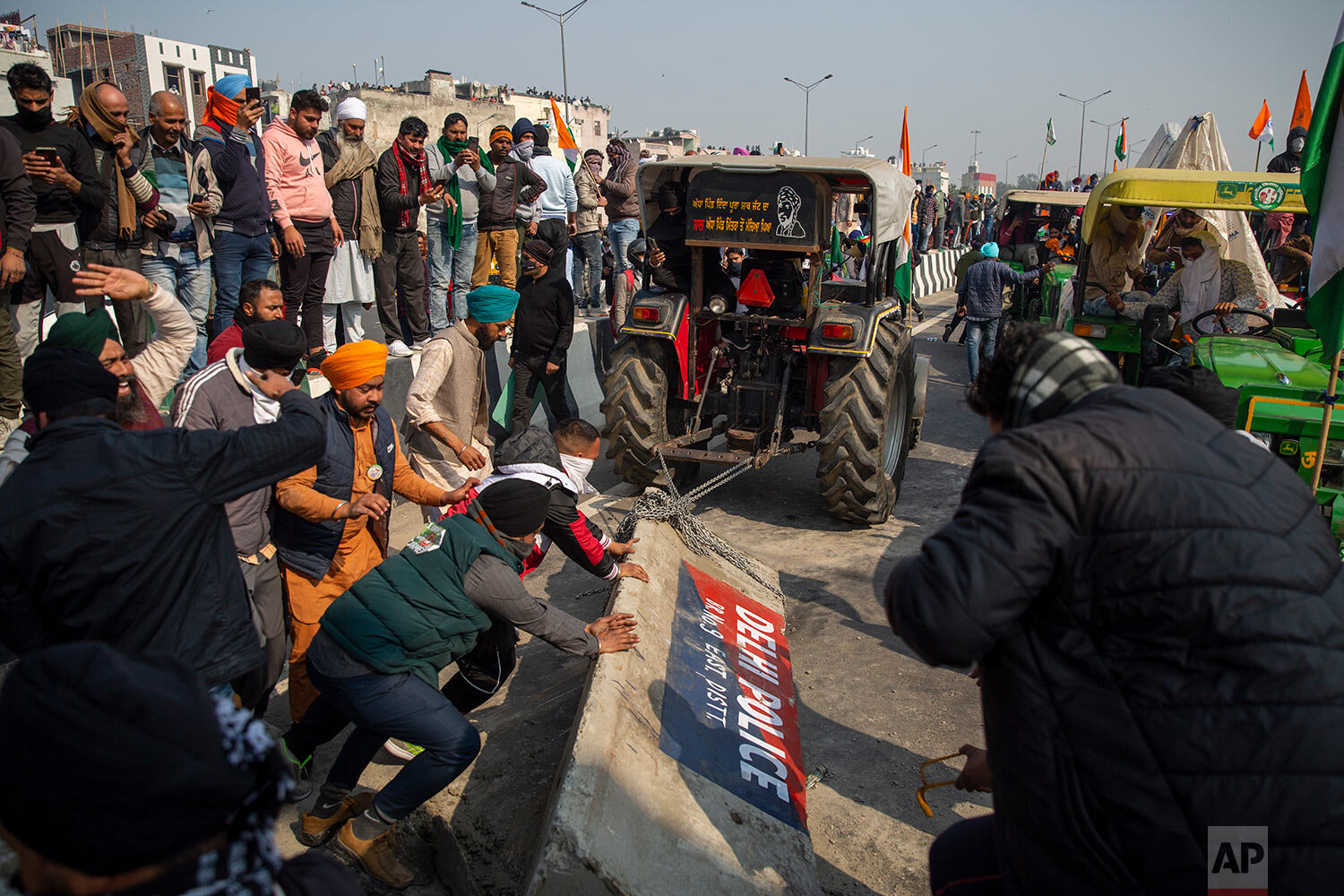  Protesting farmers remove police barricades as they march to the capital during India's Republic Day celebrations in New Delhi, India, Tuesday, Jan. 26, 2021. (AP Photo/Altaf Qadri) 