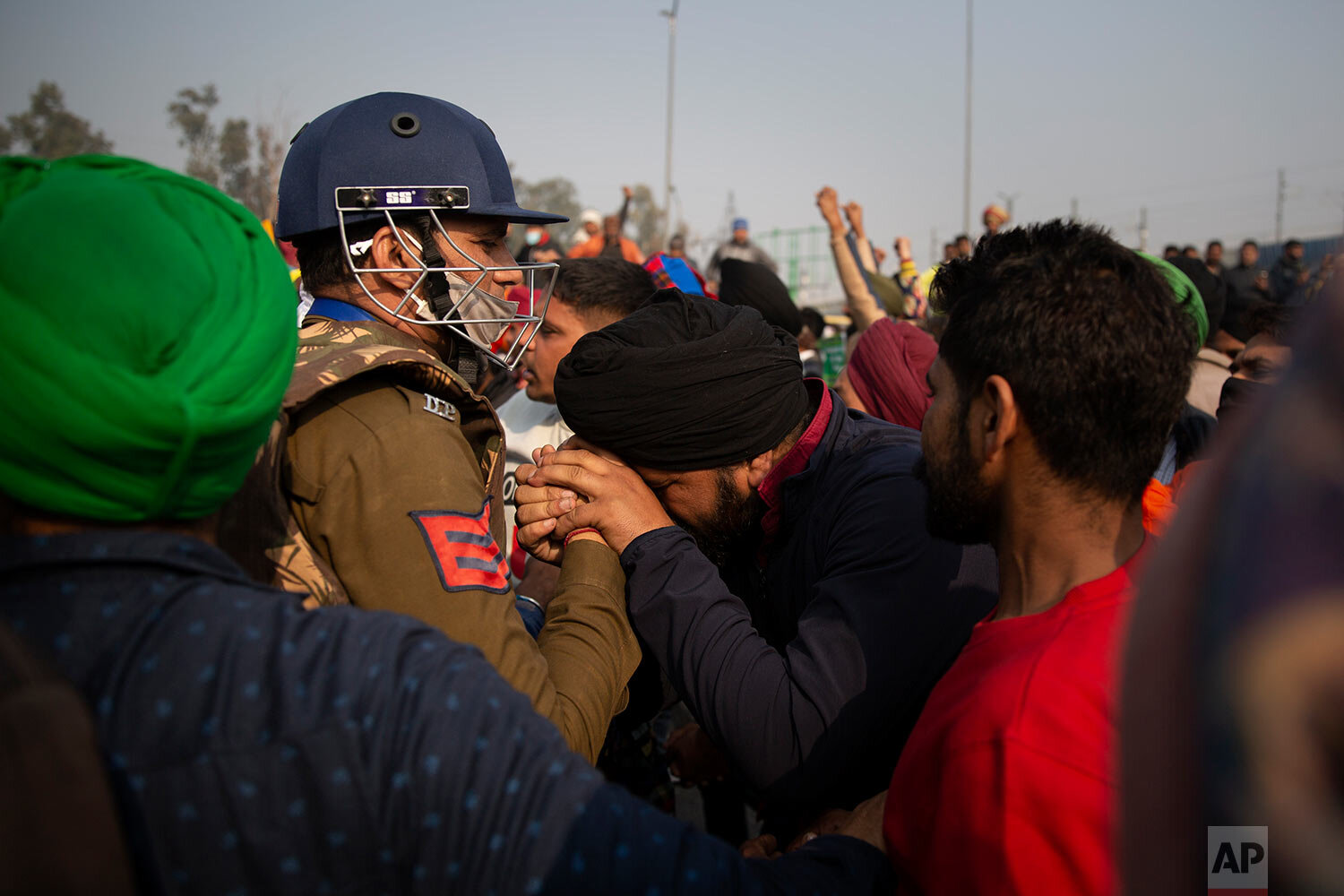  A protesting farmer pleads in front of a police officer to let them pass through a barricade at at the Delhi-Uttar Pradesh state border, India, Tuesday, Jan. 26, 2021. (AP Photo/Altaf Qadri) 