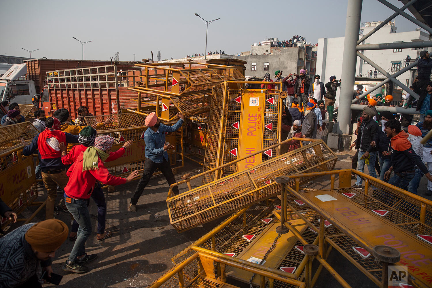  Protesting farmers remove police barricades as they march to the capital during India's Republic Day celebrations in New Delhi, India, Tuesday, Jan. 26, 2021. (AP Photo/Altaf Qadri) 