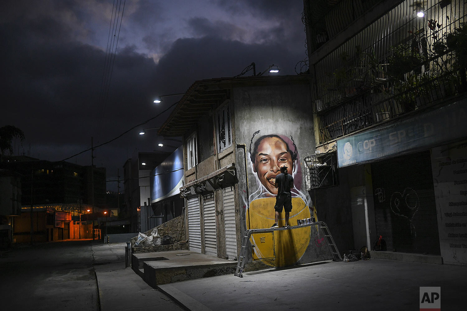  Street artist Wolfgang Salazar works on his mural featuring Venezuelan athlete Yulimar Rojas in the Boleita neighborhood of Caracas, Venezuela, Jan. 2, 2021. (AP Photo/Matias Delacroix) 