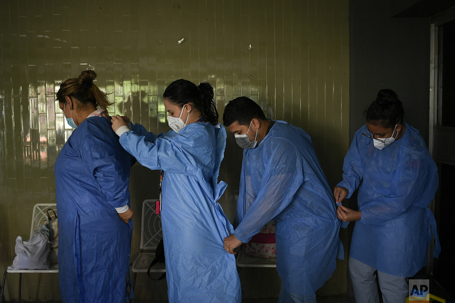  Government doctors put on protective gowns as they prepare to give free, rapid COVID-19 tests to volunteers in the El Paraiso neighborhood of Caracas, Venezuela, Jan. 14, 2021. (AP Photo/Matias Delacroix) 