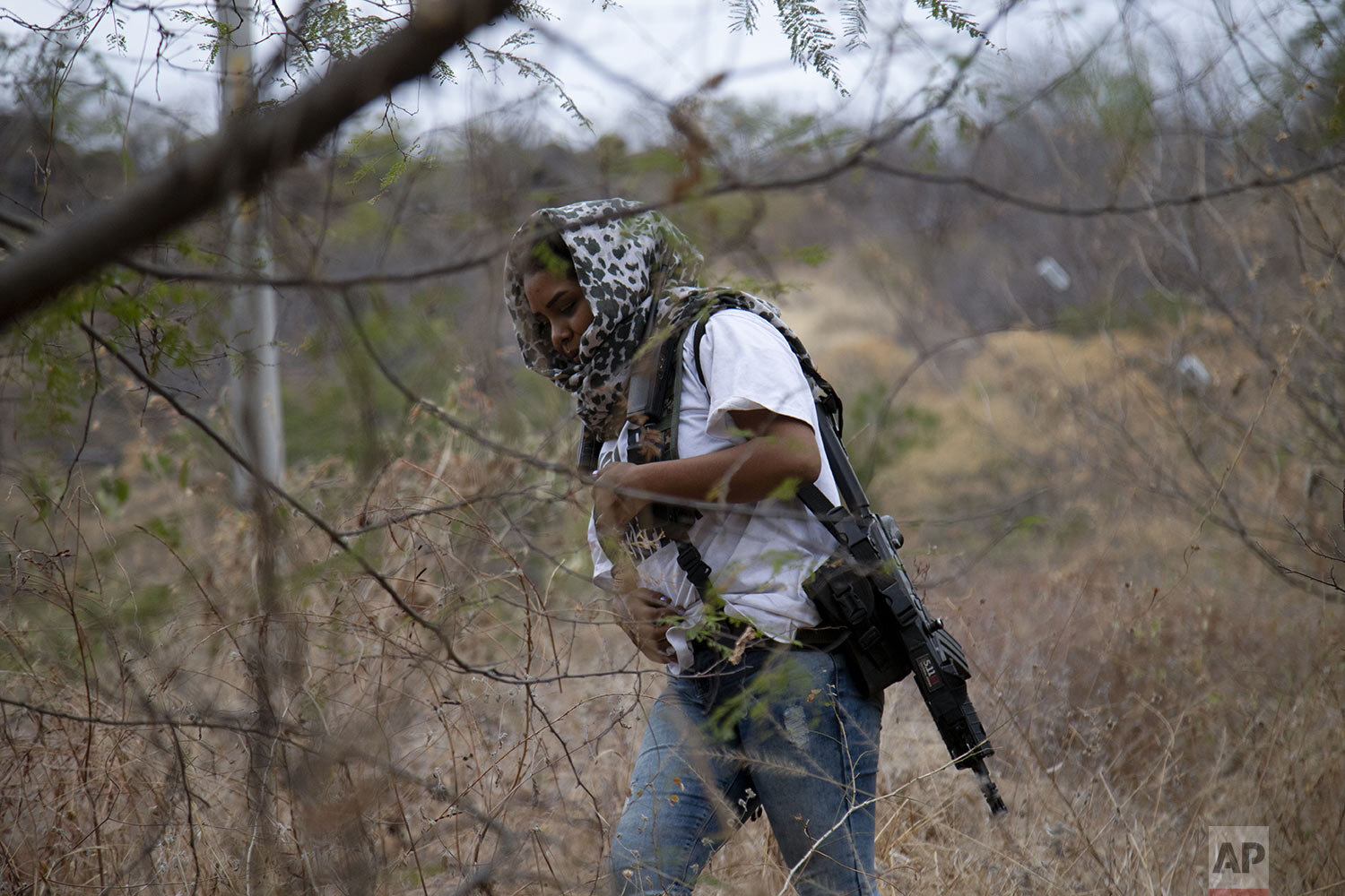  An armed woman who goes by the nickname "La Chola," and is a member of a female-led, self-defense group, patrols the edge of her town of El Terrero, where it shares a border with the town of Aguililla, in Michoacan state, Mexico, Jan. 14, 2021. (AP 