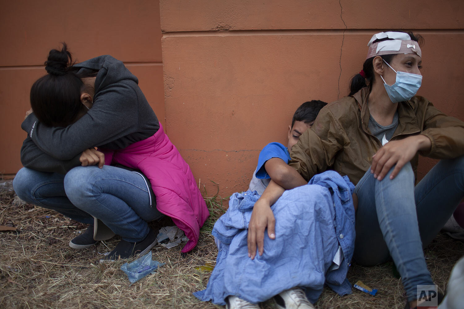  Injured Honduran migrant women with children cry on the side of a highway after clashing with Guatemalan security forces in Vado Hondo, Guatemala, Sunday, Jan. 17, 2021, as they try to reach the U.S. by foot. (AP Photo/Sandra Sebastian) 