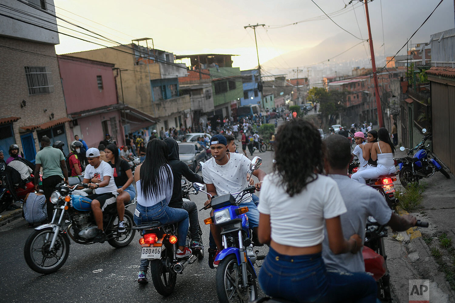  Motorcycle riders gather to see stuntman Pedro Aldana do an exhibition performance in Caracas, Venezuela, Sunday, Jan. 31, 2021. (AP Photo/Matias Delacroix) 