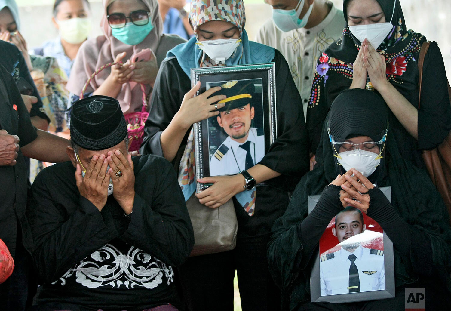  Relatives weep as they pray during the burial of Fadly Satrianto, a victim of the crash of Sriwijaya Air flight SJ-182 in Surabaya, East Java, Indonesia, Friday, Jan. 15, 2021. (AP Photo/Trisnadi) 