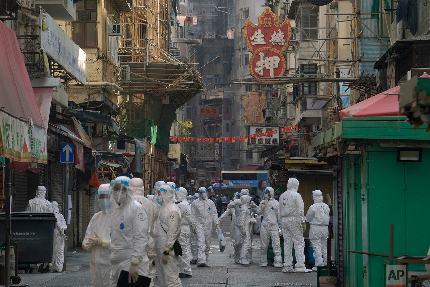  Government workers wearing personal protective equipment walk at the closed area of Jordan district in Hong Kong, Saturday, Jan. 23, 2021. (AP Photo/Kin Cheung) 