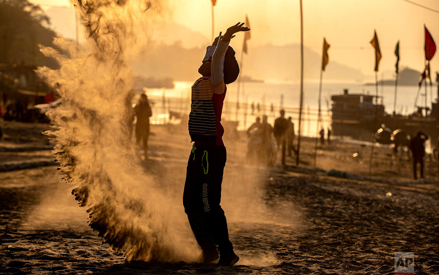  An Indian boy plays with sands on the banks of the river Brahmaputra as people gather to celebrate the New Year in Gauhati, India, Friday, Jan. 1, 2021. (AP Photo/Anupam Nath) 