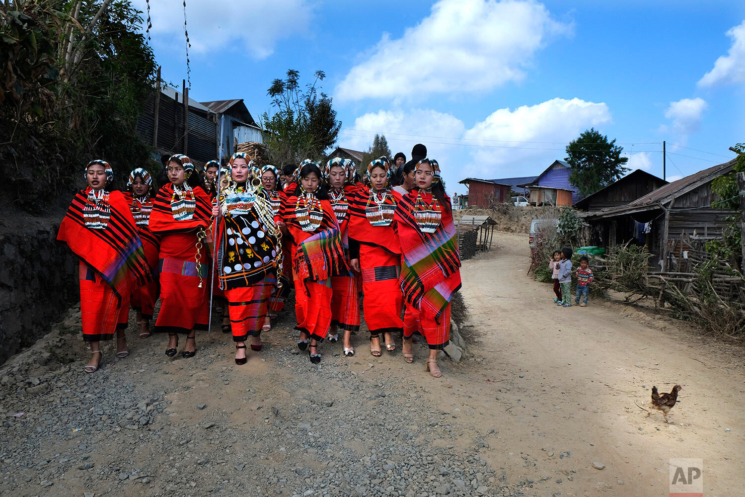  A group of Naga girls in traditional attire accompany a bride-to-be, center, as she leaves her village to travel to the village of her groom, in Shangshak village, in the northeastern Indian state of Manipur, Friday, Jan. 15, 2021. (AP Photo/Yirmiya