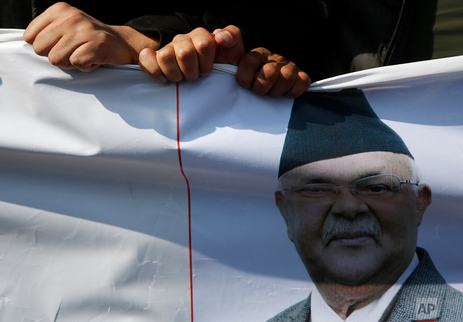  Supporters of Prime Minister Khadga Prasad Oli hold his portrait as they participate in a rally in Kathmandu, Nepal, Sunday, Jan. 3, 2021. (AP Photo/Niranjan Shrestha) 