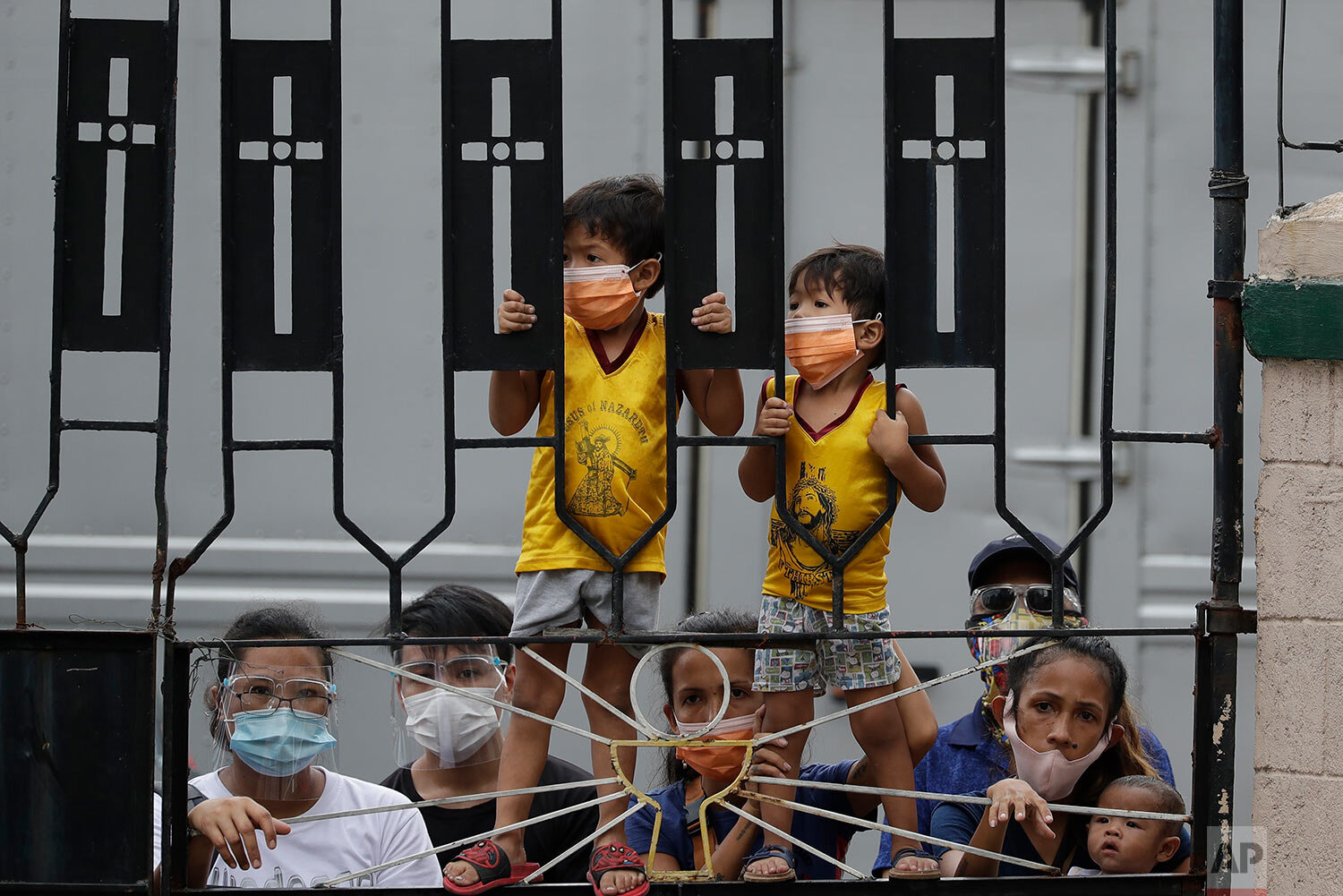  Young Catholic devotees wearing face masks to prevent the spread of the coronavirus stand try to get a glimpse of the the Black Nazarene at the Santa Cruz Church in Manila, Philippines a day before it's feast day on Friday Jan. 8, 2021.  (AP Photo/A